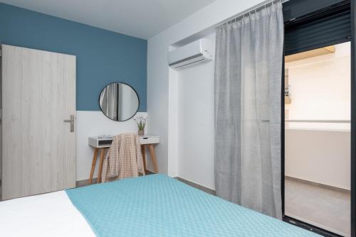 a bedroom with a bed and a mirror at PROPAN CITY SUITES in Volos