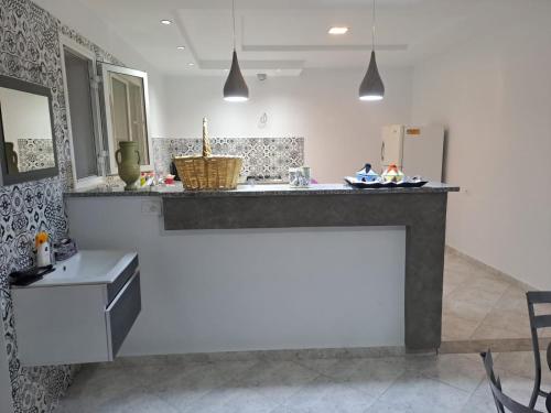 uma cozinha com um balcão e um lavatório num quarto em dari darkom em Kerkouene