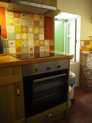 a kitchen with a stove with a counter top at Artists' Residence 2 bed, 2 bath in Megalochori