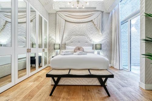 a white bedroom with a large bed and a table at ALTIDO Luxury flats near Big Ben and London Eye in London