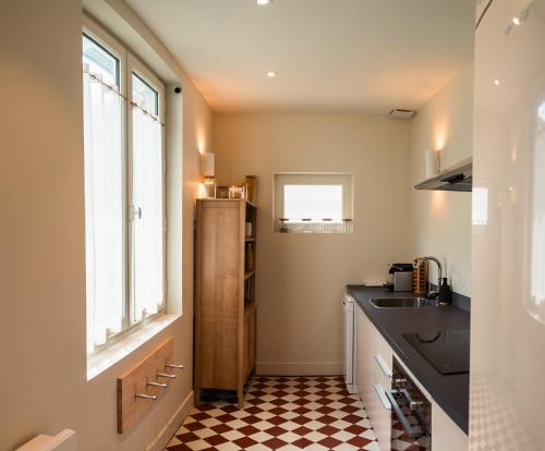 - une cuisine avec un évier et un sol en damier dans l'établissement Tanesse - Souplex 1 chambre, élégant et calme, à Bordeaux