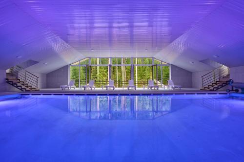 a swimming pool with chairs and a large window at Готель У Борисовича & SPA in Palyanytsya