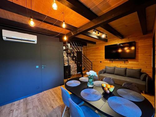 een woonkamer met een tafel en een bank bij Czarna Chata II Luxury Resort in Ropa