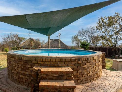 a large pool in a brick wall with a green roof at Klipdrift Sands Bush Camp in Dinokeng Game Reserve