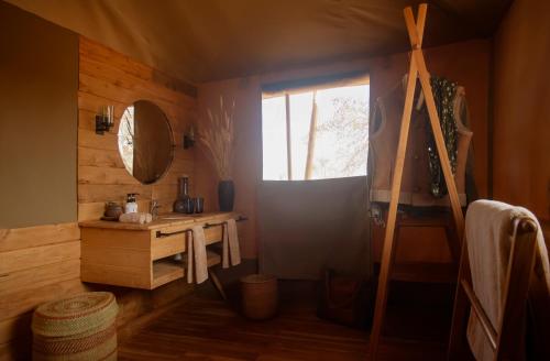 een badkamer met een raam, een wastafel en een spiegel bij Olkeri Camp in Olmotoni