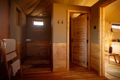 a bathroom with a wooden door in a room at Olkeri Camp in Olmotoni