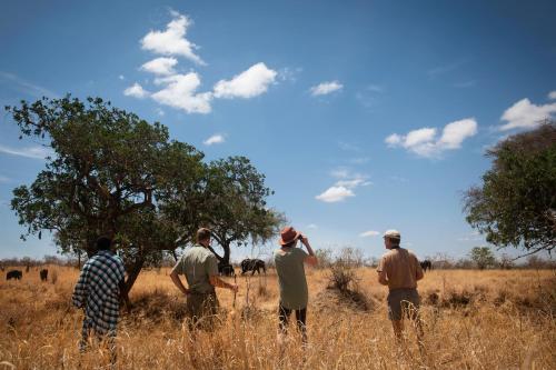 a group of men standing in a field at Olkeri Camp in Olmotoni