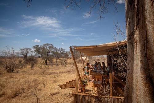 a group of people sitting at a bar in a safari tent at Olkeri Camp in Olmotoni