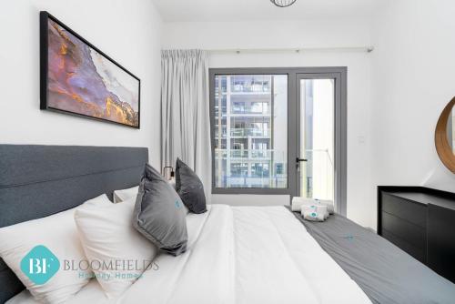 a bedroom with a large bed with a large window at Bloomfields Executive 1br In Oasis in Abu Dhabi