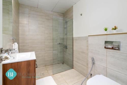a bathroom with a shower and a toilet and a sink at Executive 1 Bedroom In Oasis in Abu Dhabi