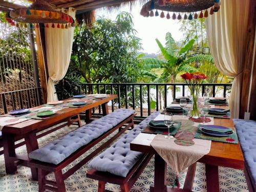 a patio with a table and chairs on a balcony at The Wooden Gate in Xuân Sơn