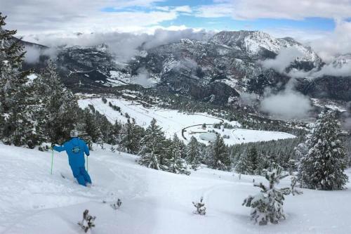 una persona en esquís en la nieve en una montaña en Port del Comte Apartment - A PIE DE PISTA, en La Coma i la Pedra
