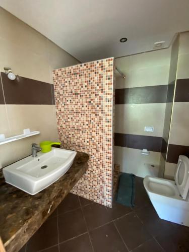 a bathroom with a sink and a toilet at Villa haut standing dans une résidence fermée in Zaouia Sidi Rahkal