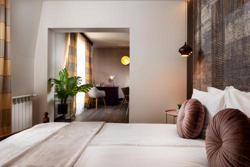 a bedroom with a large bed and a dining room at Park Hotel Kaylaka in Pleven
