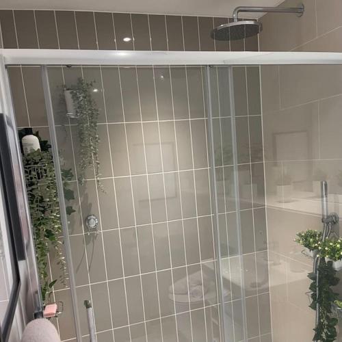 a shower with a glass door in a bathroom at Seafront apartment with spectacular views in Porthcawl