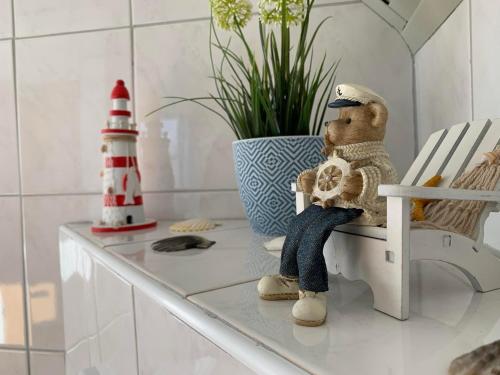 Un oso de peluche sentado en una silla en una habitación. en Harms, Ferienwohnung, en Südbrookmerland