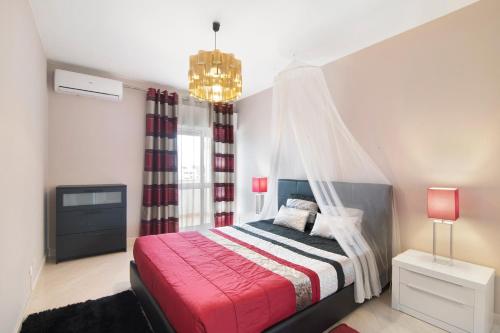una camera con letto rosso a baldacchino di Blue House ad Armação de Pêra