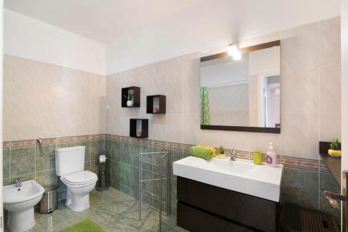un bagno con lavandino, WC e specchio di Blue House ad Armação de Pêra