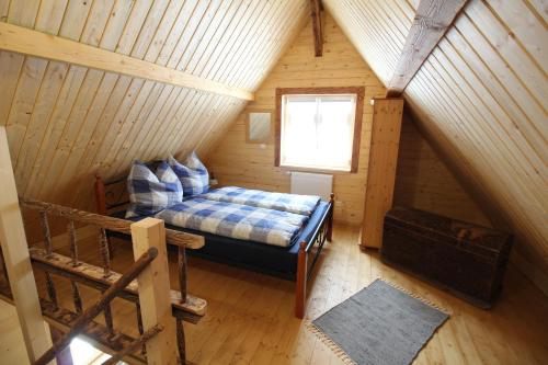 a attic room with a bed and a window at Ferienhaus Anno Dazumal, wie zu Großmutters Zeiten in Klingenthal