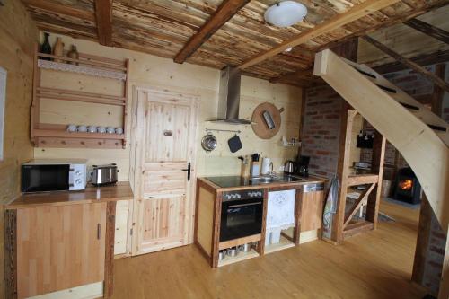 a kitchen with a stove and a staircase in a cabin at Ferienhaus Anno Dazumal, wie zu Großmutters Zeiten in Klingenthal