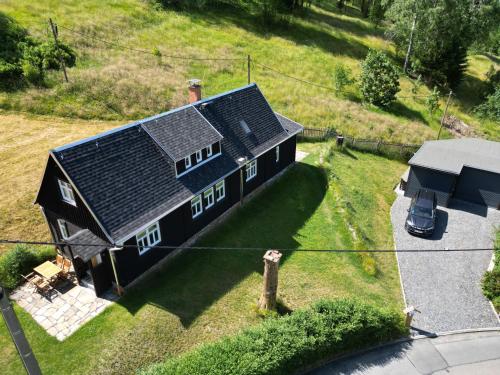 an aerial view of a black house with a car at Ferienhaus Anno Dazumal, wie zu Großmutters Zeiten in Klingenthal