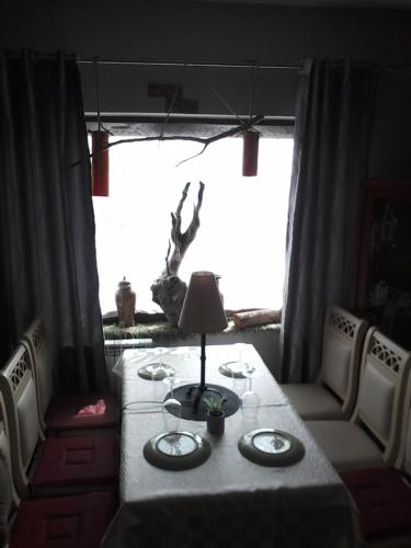 a dining room table with a lamp in front of a window at Dream Stone Holiday Bar Restaurant in Polje