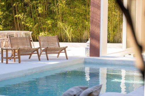 two chairs sitting next to a swimming pool at Casa dos Pinheiros 109 - Private Villa with pool & heated SPA in Porto