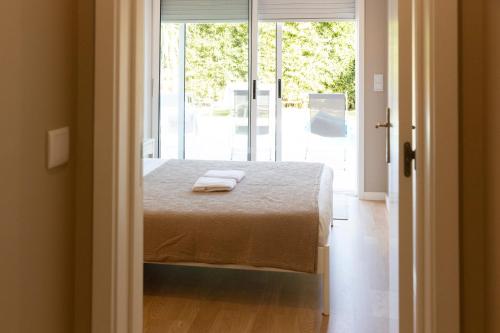 a bedroom with a bed with two towels on it at Casa dos Pinheiros 109 - Private Villa with pool & heated SPA in Porto