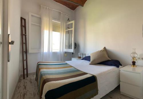 a white bedroom with a bed and a window at BlauMasnou One step to the beach! in El Masnou