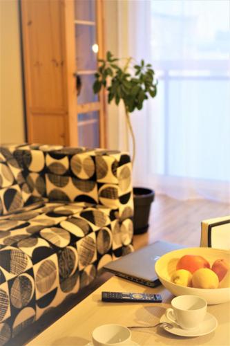 a table with a bowl of fruit and a couch at Apartament Garbary22 in Bydgoszcz