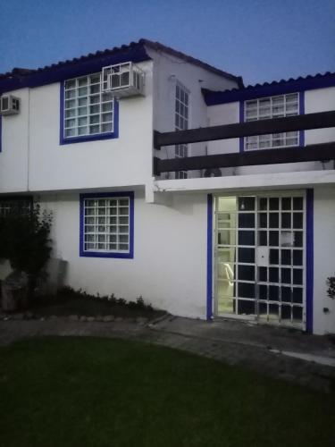 a white house with a green door at Casa en la zona de Acapulco diamante in La Sabana