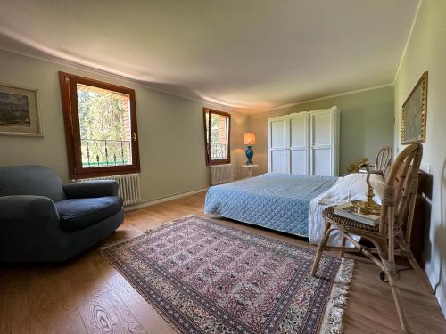 a bedroom with a bed and a couch and a rug at Eco Farm - La Cavallina in Rivoli Veronese