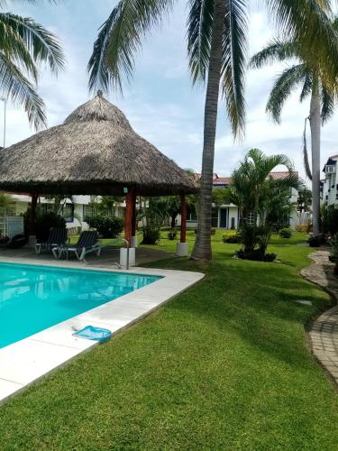 a resort with a swimming pool and palm trees at Casa en la zona de Acapulco diamante in La Sabana