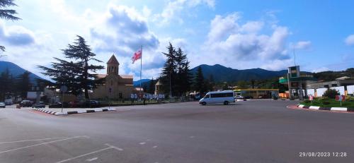 een wit busje geparkeerd op een parkeerplaats met een kerk bij Chateau Bagdati in Nerget'i