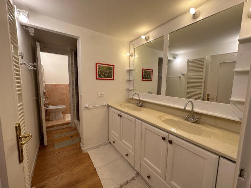 a bathroom with two sinks and a large mirror at Cavallina Retreat in Rivoli Veronese