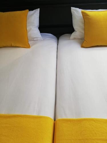 two beds with yellow pillows sitting next to each other at Céntrico dúplex con vistas, en Morella in Morella