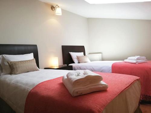 a room with two beds with red and white sheets at Céntrico dúplex con vistas, en Morella in Morella