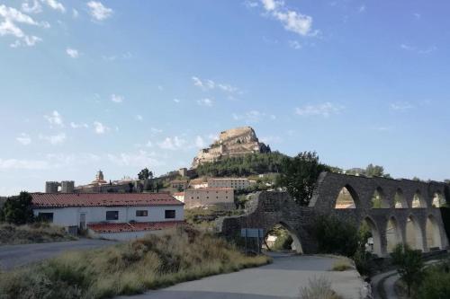 an old bridge with a mountain in the background at Céntrico dúplex con vistas, en Morella in Morella