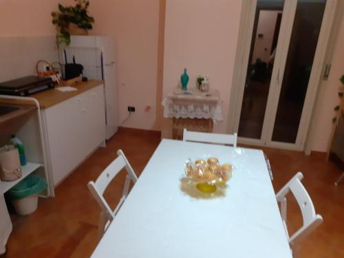 a kitchen with a white table and white chairs at La Suite dei Ricami in Agrigento