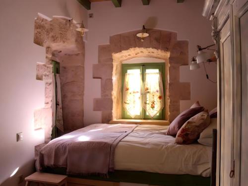 a bedroom with a bed with a window in it at Artists' Residence 2 bed, 2 bath in Megalochori