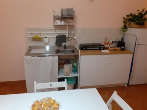 a small kitchen with a sink and a table at La Suite dei Ricami in Agrigento