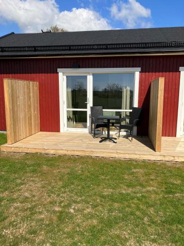 a deck with a table and chairs on a building at Bedinge Golfklubb hotell in Beddinge Strand