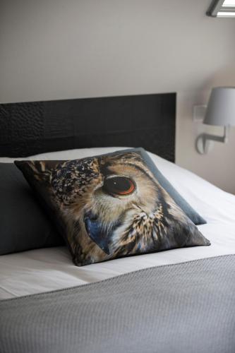 a pillow with an owl head on a bed at Erfgoed Bossem in Lattrop