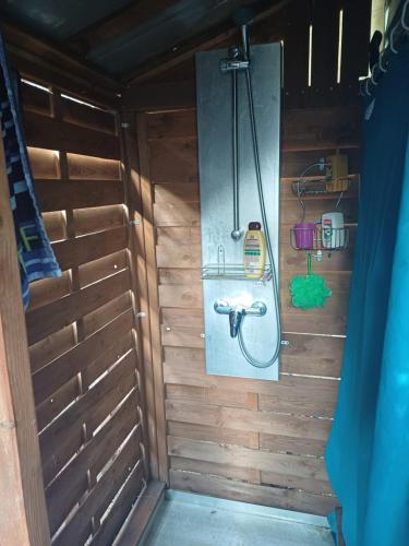 a bathroom with a shower in a wooden wall at Mobil-home proche St Trop in Gassin