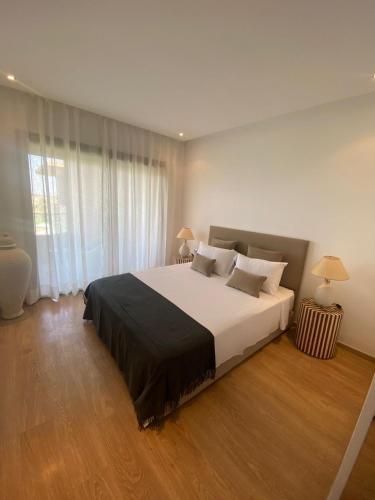 um quarto com uma cama grande e uma janela grande em Marrakech - Prestigia Golf - haut standing em Marrakech
