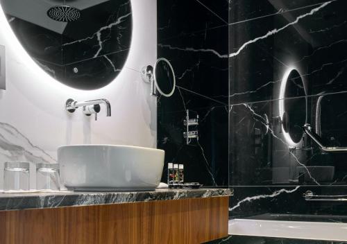 a black bathroom with a sink and a tub at Dylan in Dublin