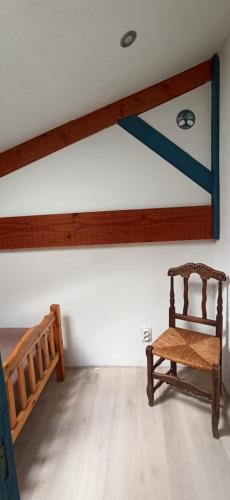 a room with a bed and a wooden chair at La Grangette in Saint-Martin-de-Villeréal