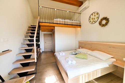 a bedroom with a bed and a spiral staircase at Ferjančič estate rooms in Ajdovščina