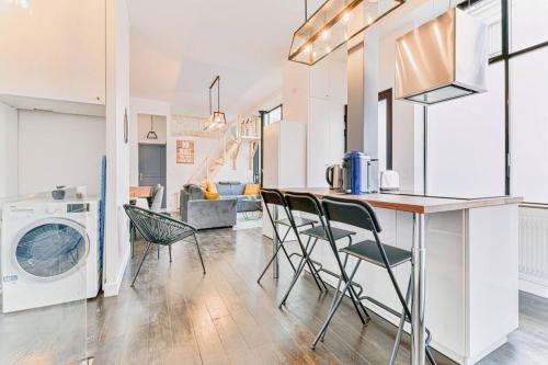 une cuisine et un salon avec laveuse et sécheuse dans l'établissement Renovated Design Apartment In Montparnasse, à Paris