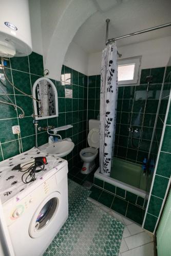 a green and white bathroom with a washing machine at Rose's Apartment in Prilep